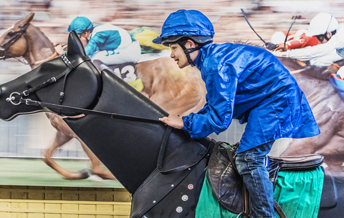 Young boy on the racing simulator at the National Horseracing Museum