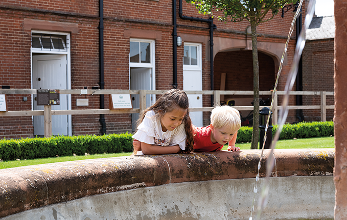 Young children looking at the historic fountain in the Rothschild Yard at NHRM